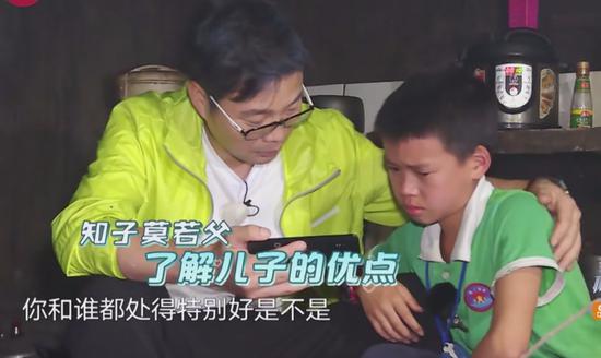 极限男人帮陪伴留守儿童，王迅正给孩子播放他爸爸的录像。/ 《极限挑战》第四季